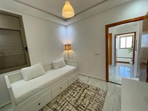 a white couch in a living room with a window at A3 Appartement entièrement neuf au cœur de Témara in Temara