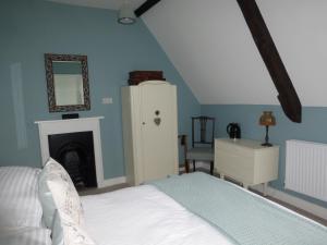 Home Farm House في Wimborne Saint Giles: غرفة نوم بسرير وخزانة ومرآة