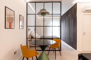 a dining room with a table and yellow chairs at Loft 404 by Wonderful Italy in Bari