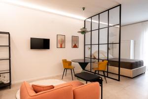 a living room with a bed and a couch and chairs at Loft 404 by Wonderful Italy in Bari