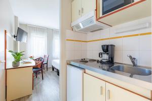 a kitchen with a sink and a counter top at Appart'City Classic Limoges in Limoges