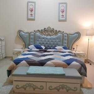 1 dormitorio con 1 cama con edredón azul y blanco en العين الهيلي مصباح بيت 3, en Al Ain