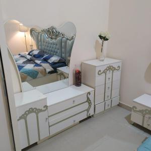 1 dormitorio con espejo, 1 cama y vestidor en العين الهيلي مصباح بيت 3, en Al Ain