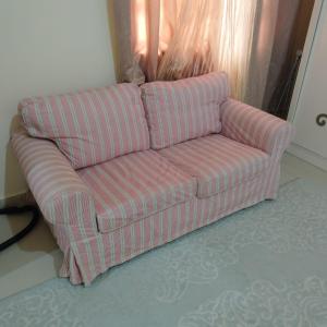 un sofá rosa sentado en una sala de estar en العين الهيلي مصباح بيت 3, en Al Ain