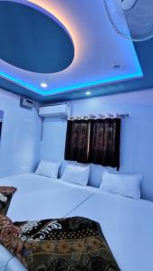 a bedroom with a large bed with a blue ceiling at Baba Vishwanath Residency in Varanasi