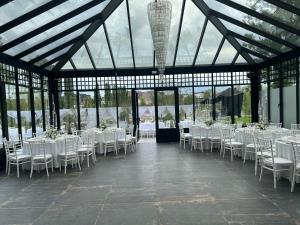 - une salle de banquet avec des tables et des chaises blanches dans l'établissement Elinoa, à Machelen