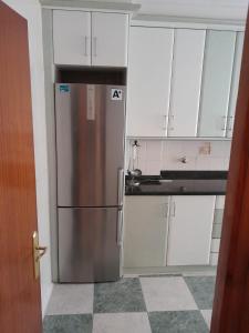 eine Küche mit einem Edelstahlkühlschrank und weißen Schränken in der Unterkunft Apartamento la catedral in Santo Domingo de la Calzada + 4 Fotos