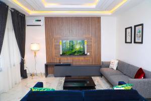 a living room with a couch and a tv at Omah Apartments in Abuja