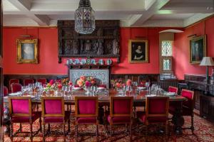a table in a room with red walls at Pentrehobyn Hall in Wrexham