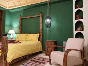 a green bedroom with a bed and a chair at Riad Jenaï L'Authentique in Marrakech