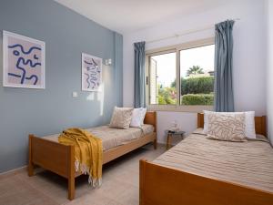 a bedroom with two beds and a window at Kyma I - Beachfront Residence At Latsi in Polis Chrysochous