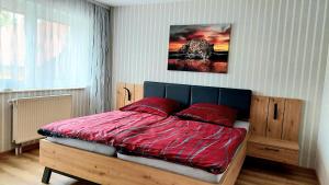 a bedroom with a bed with a red comforter at Pension Haus Germania in Erfurt