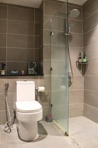 a bathroom with a toilet and a glass shower at D'CASA Riverson at Kota Kinabalu in Kota Kinabalu