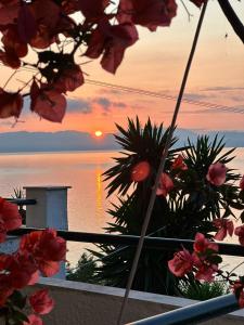 widok na zachód słońca z balkonu z kwiatami w obiekcie Ionian Sea View Studios by Hotelius w mieście Episkopianá