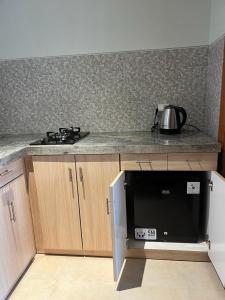a kitchen with a microwave oven and a stove at d'Leisure Guest House in Uluwatu