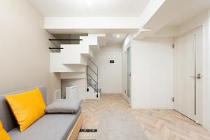 a living room with a couch and a staircase at belle ville Kagurazaka in Tokyo