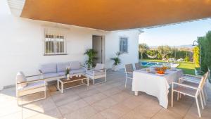 patio ze stołem i krzesłami oraz basenem w obiekcie Casa El Refugio de Paco Alhaurín de la Torre by Ruralidays w mieście Alhaurín de la Torre