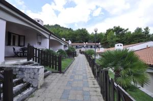a walkway next to a building with a fence at Pugnochiuso Resort Villette Belvedere in Pugnochiuso