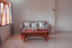 Tobay Family Home في توك توك: غرفة معيشة مع أريكة وطاولة قهوة