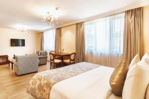 a hotel room with a bed and a living room at Sarova Woodlands Hotel and Spa in Nakuru