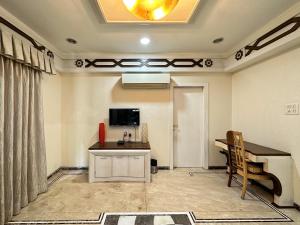 a room with a desk and a table and a television at Welcome Home Service Apartments - Andheri in Mumbai
