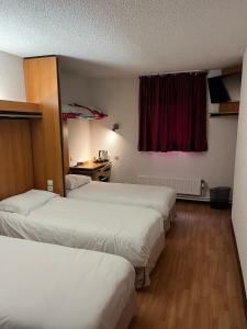 En eller flere senge i et værelse på Brit Hotel La Bonne Etape