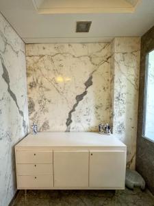 a bathroom with a marble wall at Welcome Home Service Apartments - Andheri in Mumbai