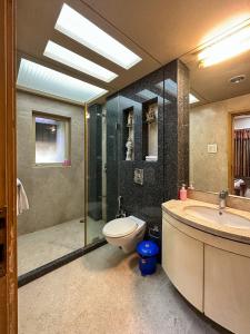 y baño con aseo, lavabo y ducha. en Welcome Home Service Apartments - Andheri, en Bombay