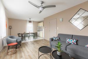 a living room with a couch and a table at Appart'City Classic Limoges in Limoges