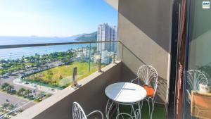 a balcony with a table and chairs and the ocean at FLC Sea Tower - Căn Hộ Biển Quy Nhơn in Quy Nhon