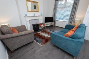 uma sala de estar com dois sofás azuis e uma lareira em Suggitt House em Hartlepool