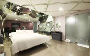 - une chambre avec un grand lit blanc dans l'établissement Rosso Hotel, à Busan