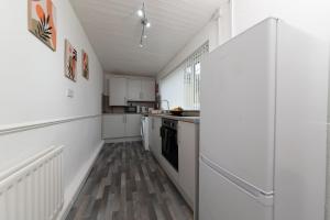 uma cozinha com paredes brancas e pisos em madeira em Suggitt House em Hartlepool