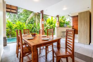 a dining room with a wooden table and chairs at Uda Suite Guest House 2 in Ubud
