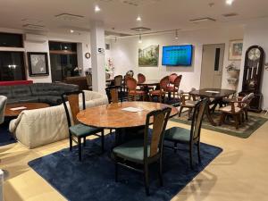 a living room with tables and chairs and a couch at Guest House Koriyama in Koriyama