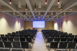 a lecture hall with chairs and a projection screen at The Valle by Kondody Hotels in Munnar
