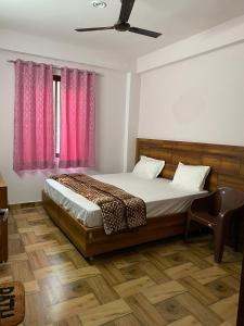 um quarto com uma cama com cortinas cor-de-rosa em Crescent Moon Homestay em Rishikesh