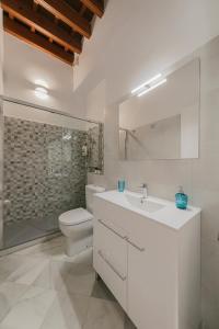 セビリアにあるArco del Postigoの白いバスルーム(トイレ、シンク付)