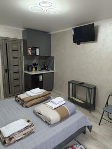 two beds in a room with a tv on the wall at Apart 41 in Almaty
