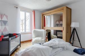 1 dormitorio con cama, espejo y silla en Grande maison de ville proche de Disney, en Faremoutiers