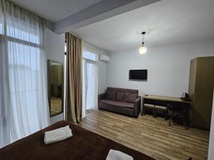 a hotel room with a couch and a television at IVERIABEACH in Kobuleti