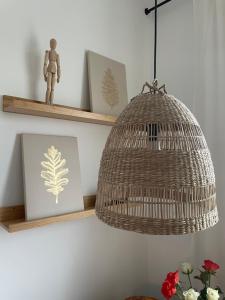 a rattan light hanging from a wall with shelves at AnnApartment in Berlin