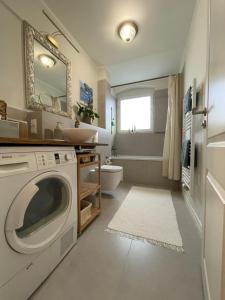 uma casa de banho com uma máquina de lavar roupa e um lavatório em AnnApartment em Berlim