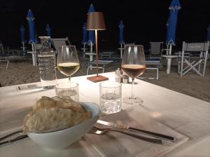 een tafel met twee glazen wijn en een kom brood bij Seashell Piombino in Piombino