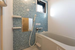 La salle de bains est pourvue d'une baignoire et d'une fenêtre. dans l'établissement Ferio Kamata, à Tokyo