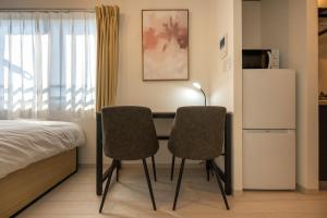 sypialnia z biurkiem z 2 krzesłami i łóżkiem w obiekcie Ferio Kamata w Tokio