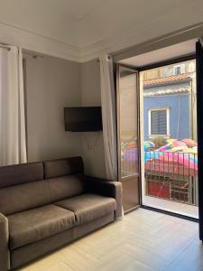 een woonkamer met een bank en een groot raam bij Riccioli Home in Catania