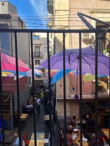 een groep mensen die aan tafels onder parasols zitten bij Riccioli Home in Catania