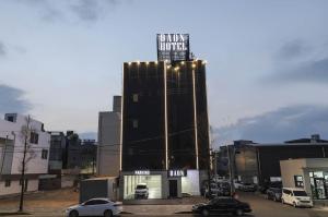 Un grand bâtiment avec des voitures garées dans un parking dans l'établissement Hotel Daon, à Pohang