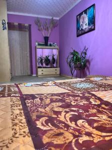 a room with purple walls and a bed with a rug at Гостевой коттедж 